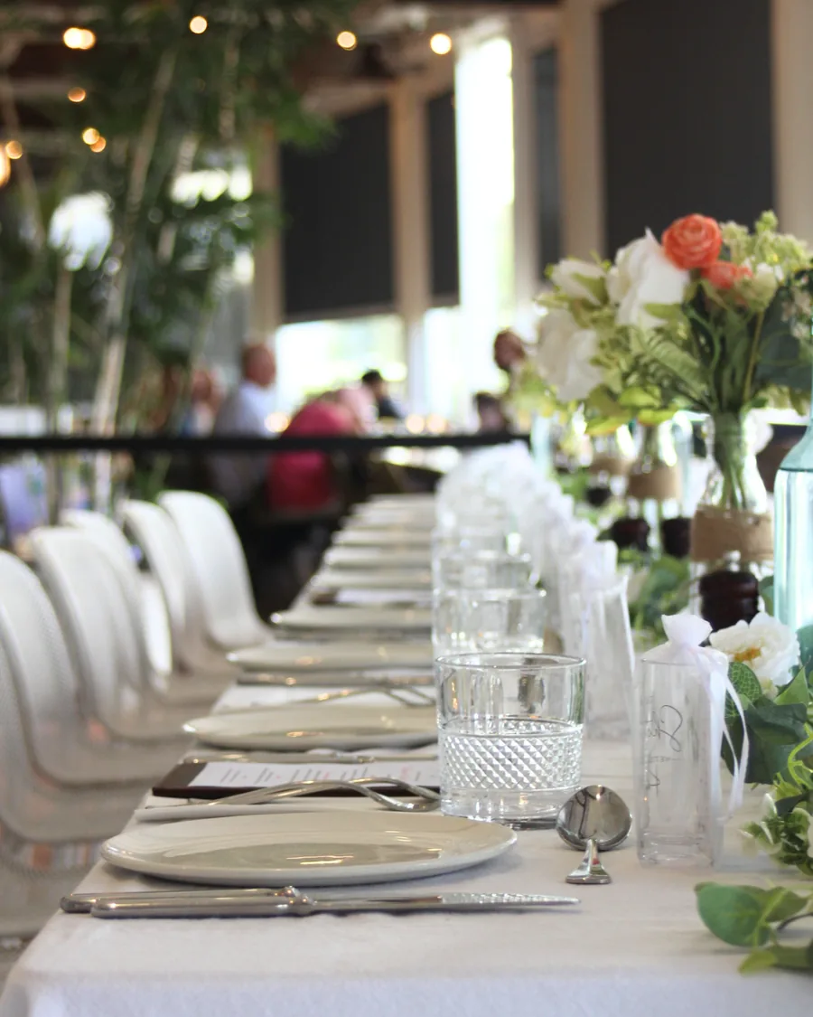 A long wedding table dressed with white linen and flowers