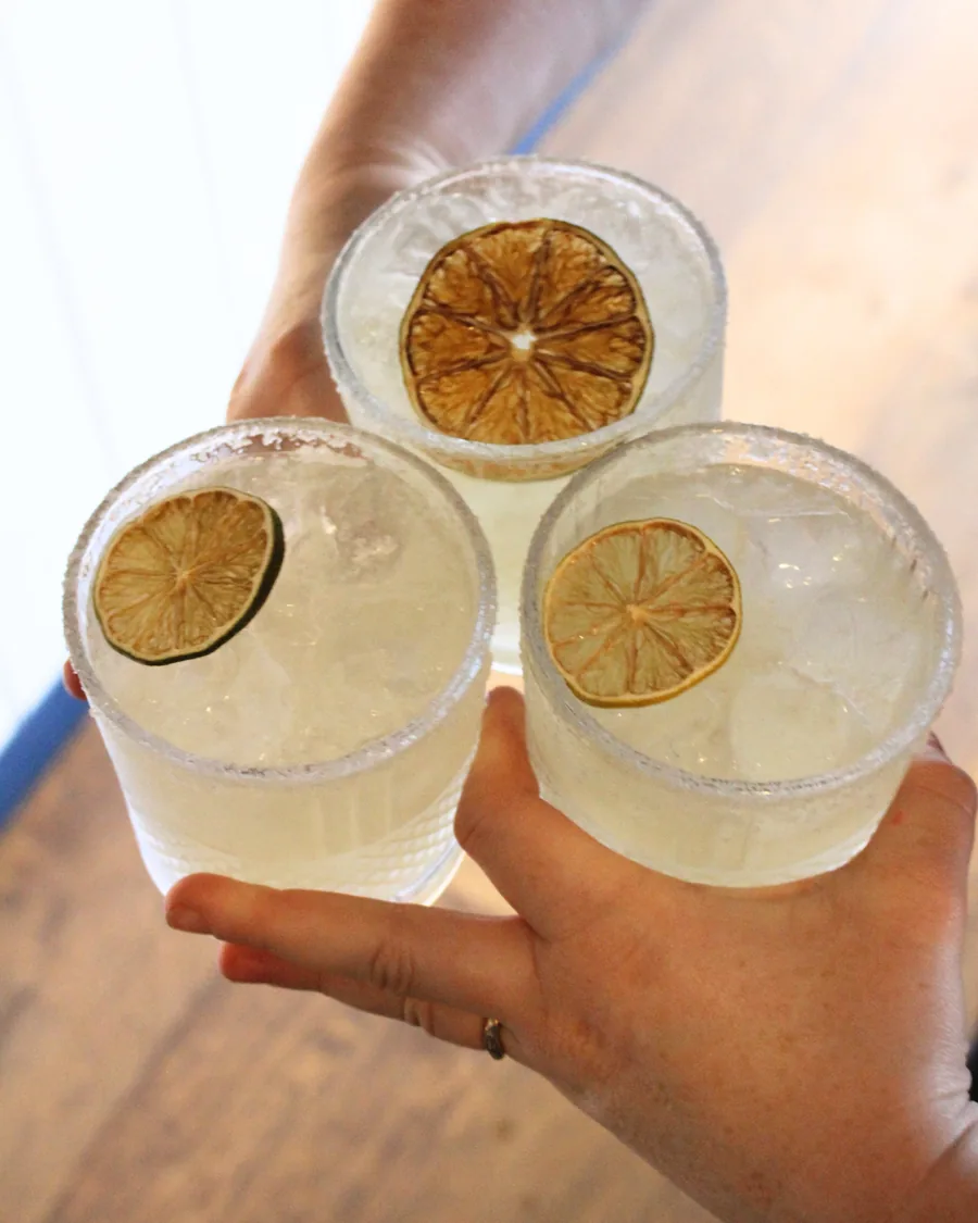 Three margaritas held up in a toast